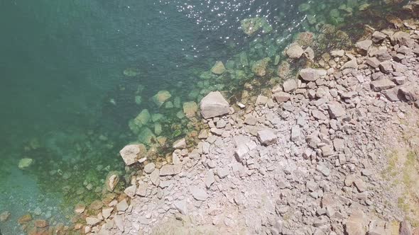 Overhead view of beautiful clear ocean water and rocks at Torquay, England.