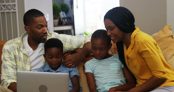 Family using laptop in living room 4k