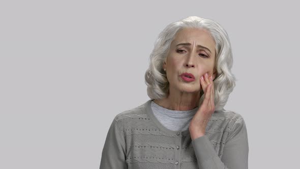 Old Lady Touching Her Cheek Because of Toothache