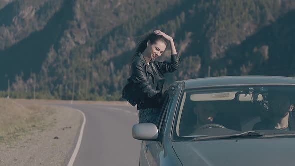 Lady Sits on Car Window and Straightens Long Dark Hair