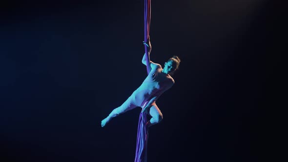 A Talented Female Circus Performer Balances on Airy Silk