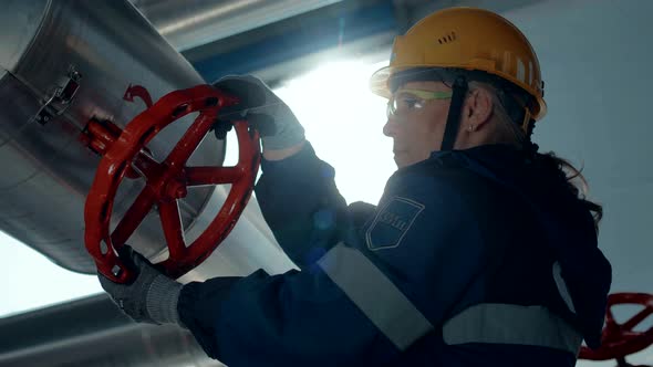 Oil worker rotates a huge pipe valve