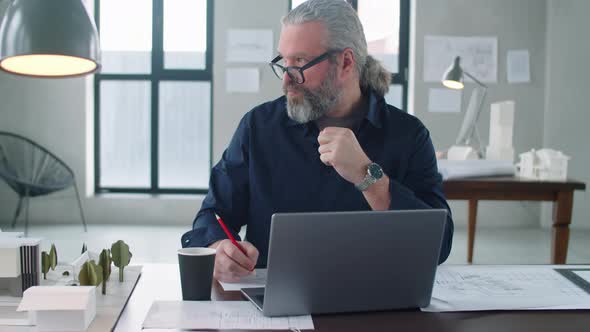 Senior Architect Working at Desk in Office