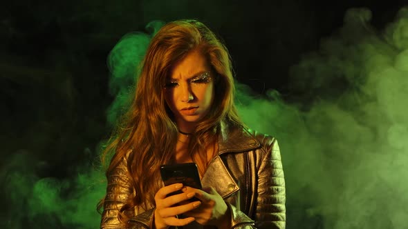 Portrait of Young Upset Pretty Woman Is Texting Then Indignantly Shows Smartphone with a Blue Screen