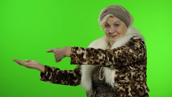 Elderly Stylish Grandmother. Caucasian Woman Pointing at Something with Hand