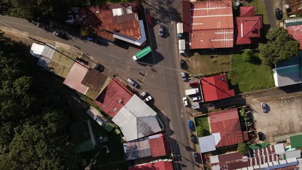 Slowly ascending high angle shot of a busy intersection in a small and remote Costa Rican town. Tin