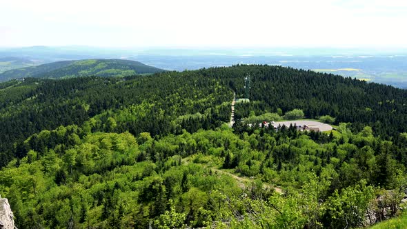 A Vast Hilly Forest Area, a Path on a Side, the Bright Sky in the Background - Top View