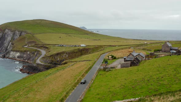 Car Driving on Narrow Coastal Road in Countryside