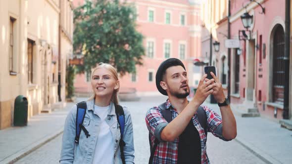 Young Tourist Couple Walking on the Street and Making Photos on Smartphone