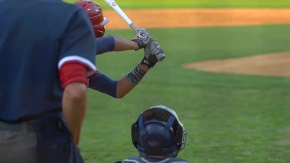 A batter at a baseball game prepares to swing the bat and hit the ball.