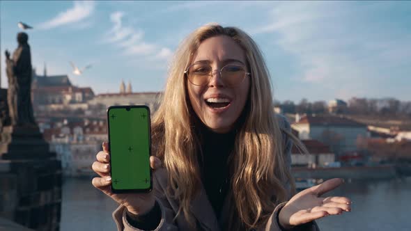 Woman Holding a Phone with Green Screen Outside