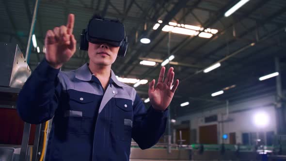 Engineer is using virtual reality glasses to inspect the factory's mechanical control system.