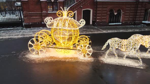 Golden Carriage with Horses Made of Luminous Garlands in the City Square