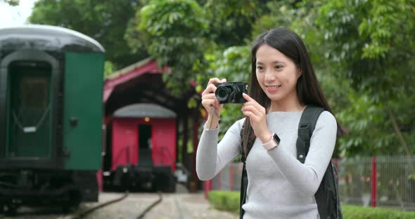 Woman Travel and Taking Photo on Digital Camera at Train Station