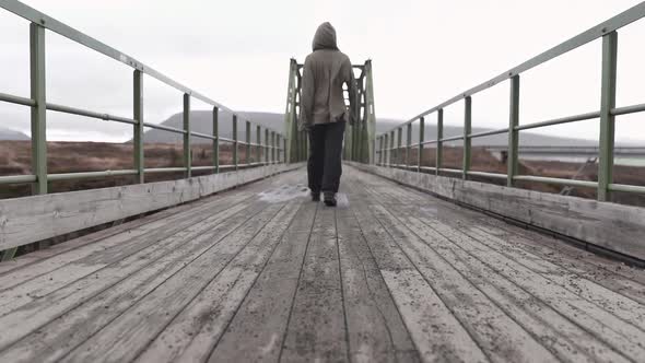 Anonymous man standing on bridge in gloomy day