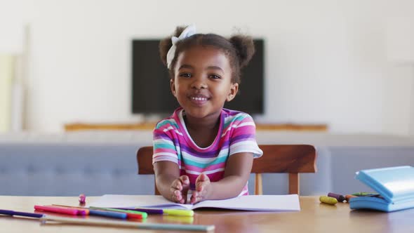 Happy african american girl having online school at home