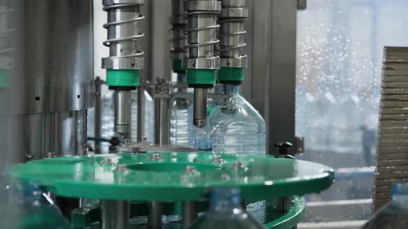 The process of leaving plastic five-liter bottles from the filling machine