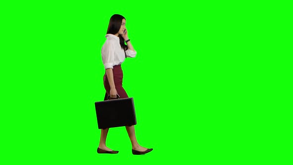 Asian Girl Looks on the Phone and Runs. Green Screen