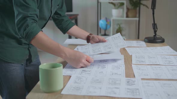 Creative Designer Works On A Storyboard, Choosing The Best Drawings For His Project