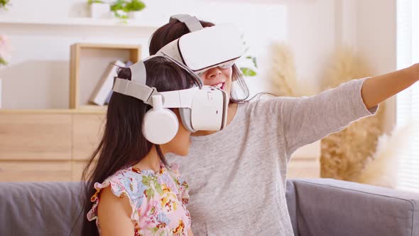 Asian mother and daughter are looking into virtual reality glasses, watching movies or online conten