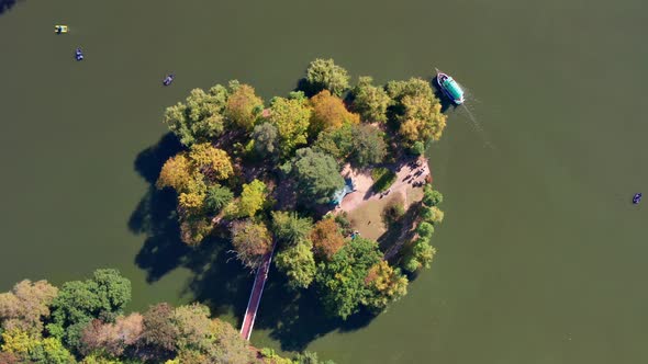 Top view of the lake and the island. People swim on a boat, boats on the lake.