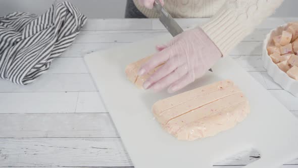 Step by step. Cutting homemade candy cane fudge on a white cutting board.