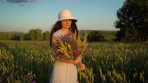 Young Woman Walking With Bouquet of Field Flowers