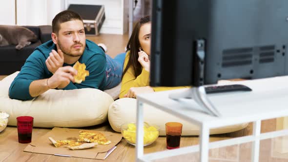 Revealing Shot of Young Couple Watching Tv