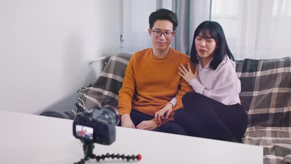 Young Asian Couple of Influencers Speaking and Recording Video Message or Streaming on Social Media