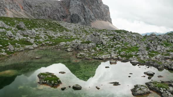 Drone Flight Over Pond Towards Mountain Peak