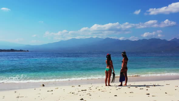 Beautiful ladies tan on idyllic bay beach break by transparent ocean and bright sand background of G