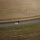 A White Car Is Driving Along an Asphalt Road Trip Among Fields. Aerial Shot Drone. Top View - VideoHive Item for Sale