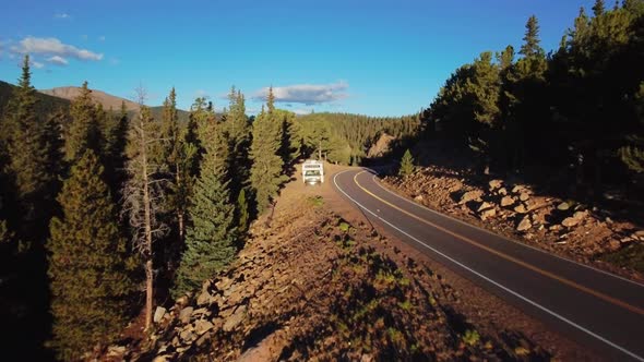 Drone slowly moves over the tops of pine trees on the slope of the high mountain in Colorado, USA