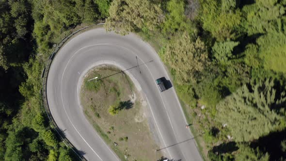 Aerial Shot SUV Automobile Driving on Serpentine Road at Dense Green Tree and Forest Nature