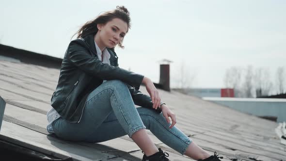 Hipster Girl Sits on the Roof and Enjoys a Warm Spring Day.