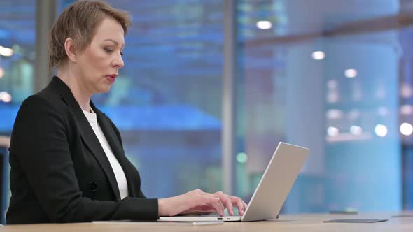 Old Businesswoman Coughing While Working in Office