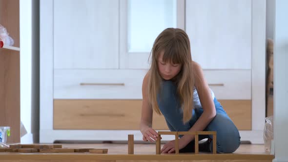 Creative Child Girl Playing with Game Stacking Wooden Toy Blocks in High Building Structure
