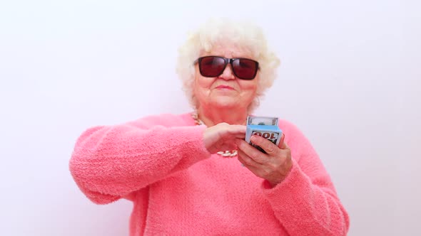 Blonde Old Lady Wear Pink Sweater and Sunglasses Tossing Money Isolated White Background