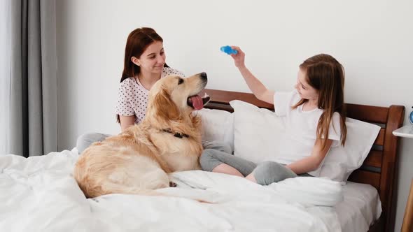 Girls with Golden Retriever Dog in the Bed