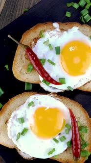 Fried Egg Sandwich with Yolk Chili Pepper on Toasted Slice of Bread Sprinkled with Green Onions