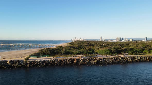 Revealing high drone view of a shipping channel next to an ocean wastewater outlet with a rising met