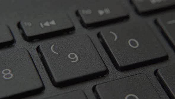 The Finger Presses a Button with a Number on the Keyboard