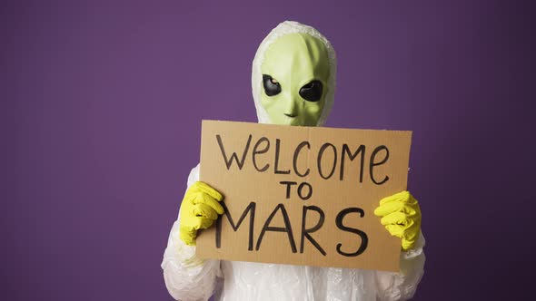 Alien Lifts a Toddler with the Inscription Welcome to Mars on a Purple Background