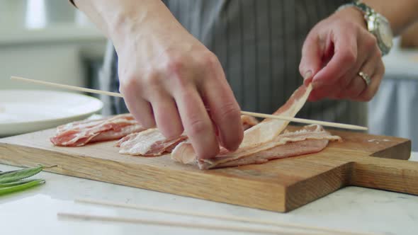 Woman making saltimbocca consisting of veal with prosciutto and sage