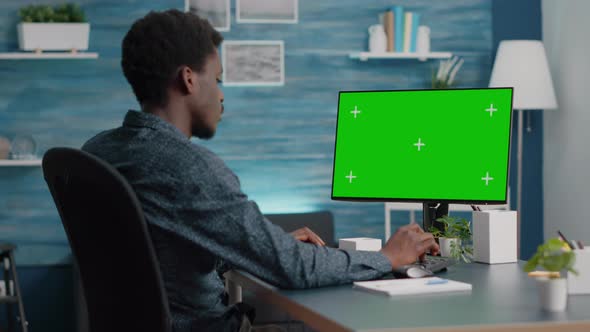 African American Man Using and Typing on Mockup Computer with Green Screen