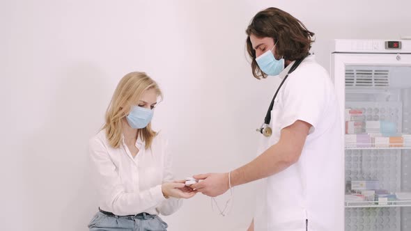 Doctor Measuring Pulse Rate And Oxygen Levels With Pulse Oximeter