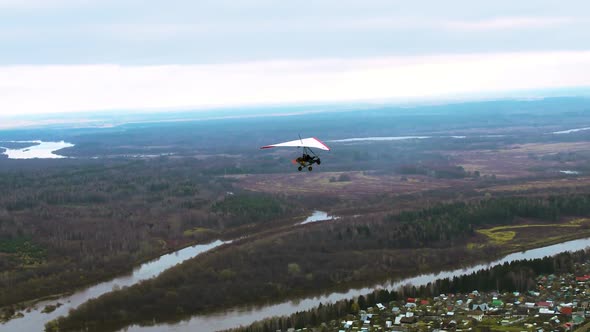 A Flight of a Hang Glider Over the River and Suburb