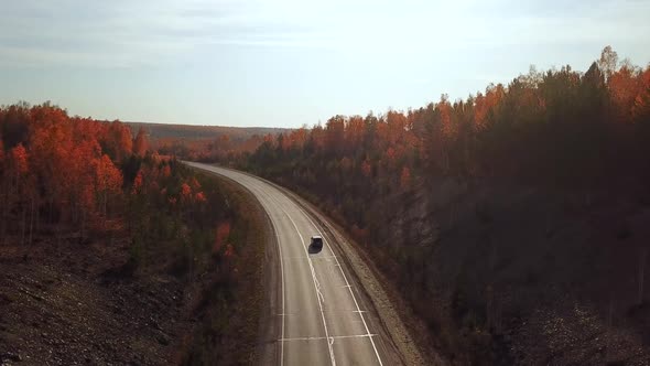 Aerial View of Car Driving on Sunny Fall Country Road Highway.