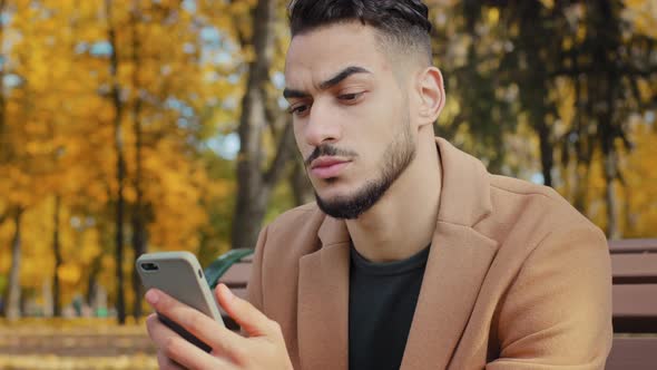 Portrait Young Serious Guy Use App Hispanic Man Looking at Phone Screen Browses News on Telephone