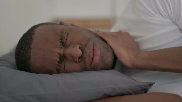 Close Up of African Man Having Neck Pain While Sleeping in Bed